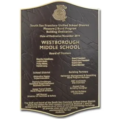 Curved bronze plaque with raised logo on dark brown leather texture